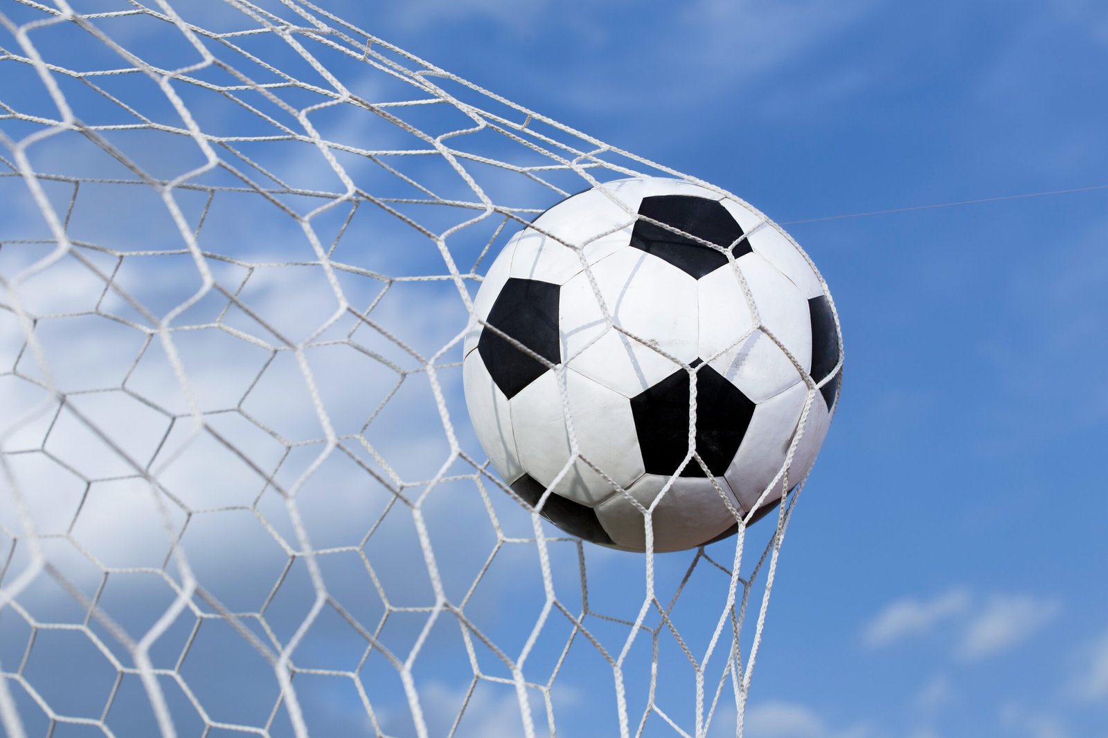 soccer-ball-in-the-net-on-blue-sky-background-2023-11-27-05-13-00-utc